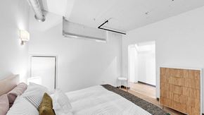 Minneapolis apartment for rent - A bedroom with a large bed and a wooden cabinet.