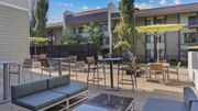 Bloomington apartment for rent - A patio with a table and chairs is surrounded by a black fence.
