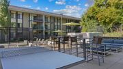 Bloomington apartment for rent - A patio area with a table and chairs is in front of a building.