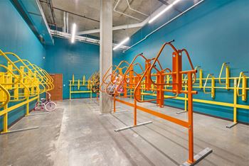 A gym with orange and blue walls and a bicycle in the corner