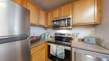 A kitchen with stainless steel appliances and wooden cabinets