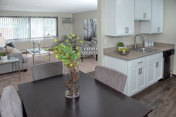 Minneapolis apartment for rent - a kitchen and living room with a table and a vase with flowers