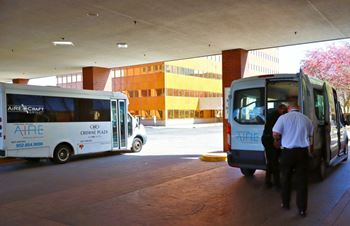 Two aire craft buses are parked in a covered area.