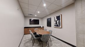 Bloomington apartment for rent - A conference room with a table, chairs, and two framed pictures on the wall.