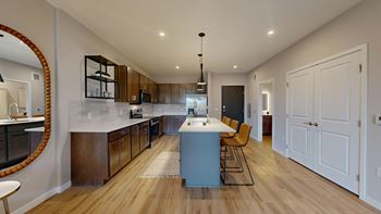 A modern kitchen with wooden floors and a large island.