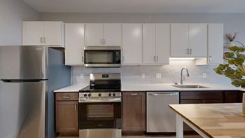 A modern kitchen with stainless steel appliances and wooden cabinets.