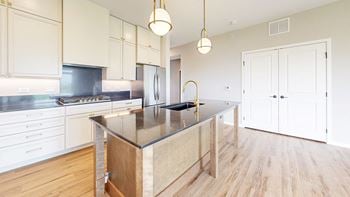 A kitchen with a wooden island and white cabinets.