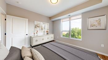 A bedroom with a large bed and a dresser with a mirror