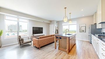 Bloomington apartment for rent - an open living room with a kitchen and a tv