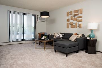 Eagan apartment for rent - a living room with a black couch and a large window