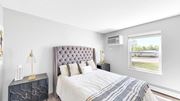 Bloomington apartment for rent - A bedroom with a large bed and a window overlooking a street.