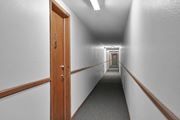 Bloomington apartment for rent - a long hallway with wooden doors and white walls