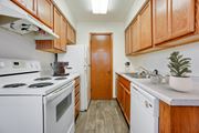 Bloomington apartment for rent - a kitchen with white appliances and wooden cabinets