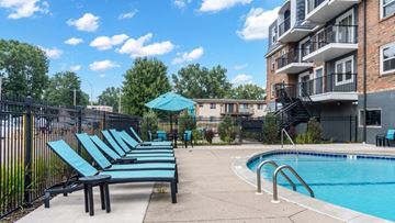 West Saint Paul apartment for rent - A pool area with a row of lounge chairs and a building in the background.