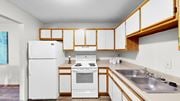 Eagan apartment for rent - A white refrigerator and oven in a kitchen with wooden cabinets.