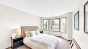 Eagan apartment for rent - A bedroom with a large bed and a nightstand with a lamp.