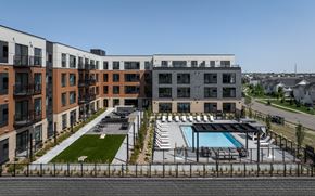 Rosemount apartment for rent - A modern apartment complex with a pool and a fenced-in parking area.