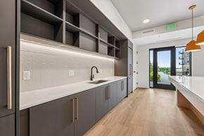 Rosemount apartment for rent - A modern kitchen with dark grey cabinets and a wooden floor.