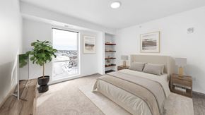 Rosemount apartment for rent - A bedroom with a large bed and a potted plant.