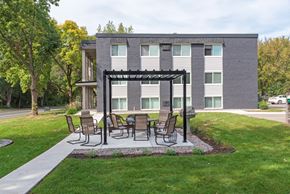 Chaska apartment for rent - a patio with a table and chairs in front of a building