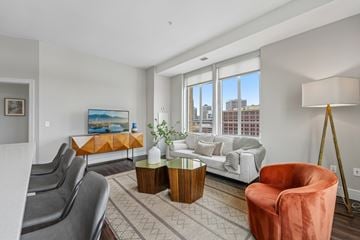 Saint Paul apartment for rent - A living room with a grey couch, a red chair, and a painting on the wall.