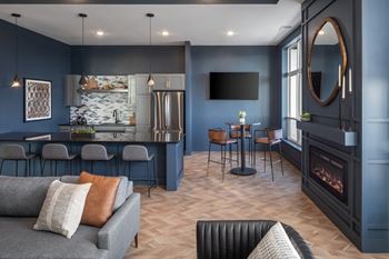 A modern living room with a grey sofa and a fireplace.