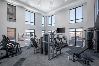 A gym with a variety of equipment including treadmills, weights, and exercise machines.