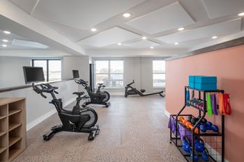 A room with exercise equipment and a rack of kettlebells.