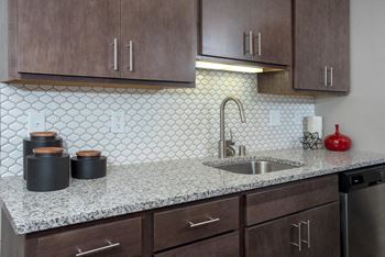 Granite countertops with modern backsplash details in kitchen at eagan place apartments