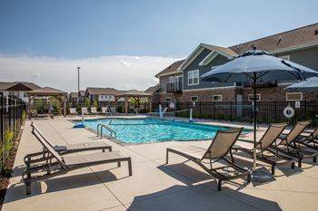 A pool surrounded by chairs and umbrellas.