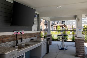 A kitchen with a sink and a bar stool.