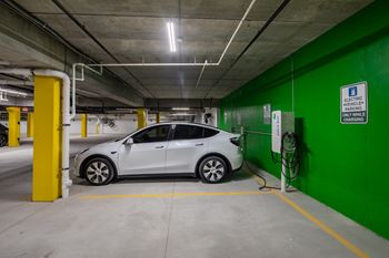 A white car is parked in an underground parking garage.