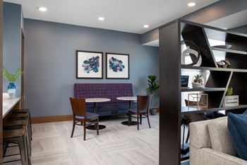 A modern living room with a purple couch and a wooden table.