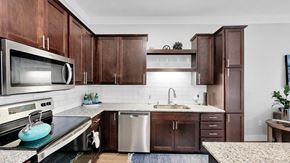 Lakeville apartment for rent - A kitchen with brown cabinets and a white backsplash.