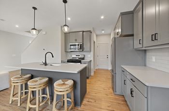 A kitchen with a center island and three stools