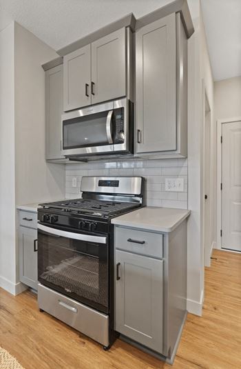 A kitchen with stainless steel appliances and white cabinets