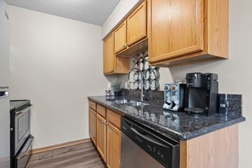 Minneapolis apartment for rent - A kitchen with wooden cabinets and black appliances.