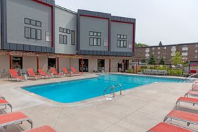 Saint Paul apartment for rent - a swimming pool with chaise lounge chairs and a building in the background