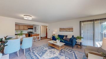 Roseville apartment for rent - a living room with blue furniture and a kitchen with a sliding glass door