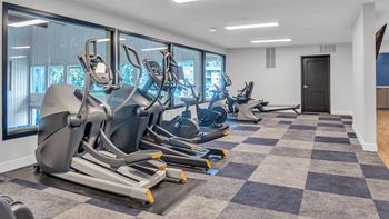 A gym with treadmills and elliptical machines.