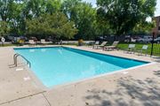 New Brighton apartment for rent - a swimming pool with lounge chairs and trees in the background