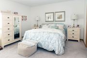 Eden Prairie apartment for rent - a bedroom with white walls and a bed with a white comforter and blue pillows