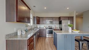 Chaska apartment for rent - A kitchen with brown cabinets and a granite countertop. at Lake Jonathan Flats, Minnesota, 55318