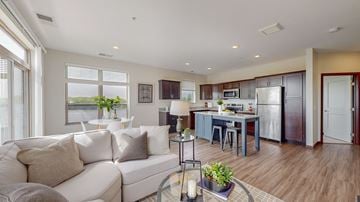 Chaska apartment for rent - A modern living room with a white couch and a kitchen in the background.