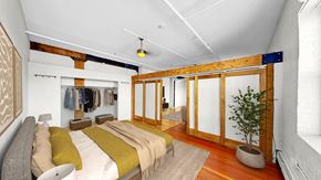 Minneapolis apartment for rent - A bedroom with a bed and a potted plant.