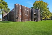 Brooklyn Center apartment for rent - a building with a wooden facade on a green lawn