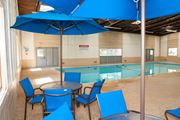 Brooklyn Park apartment for rent - a large swimming pool with blue chairs and umbrellas
