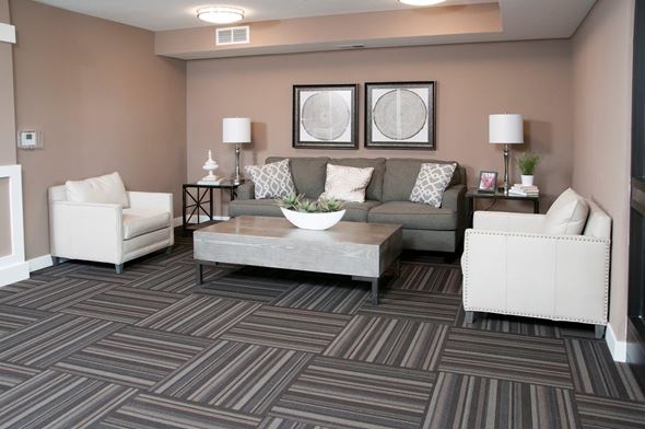 Carver apartment for rent - Carver Crossing Lobby with Large Grey Couch and Two White Leather Chairs