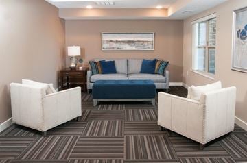 Lakeville apartment for rent - a living room with a blue couch and two white chairs