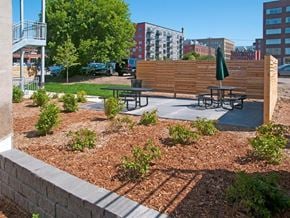 Minneapolis apartment for rent - A wooden fence separates a parking lot from a picnic area at The Cameron North Loop, Minneapolis, MN 55401